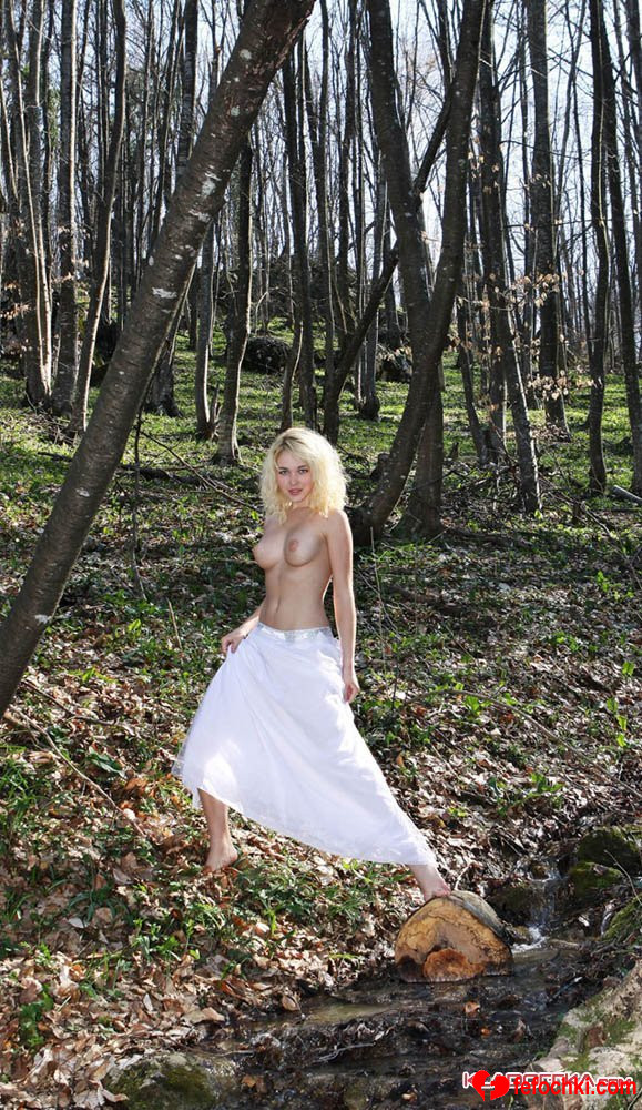 Раскрепощённая голая блондинка делает частные эротические фото в лесу
